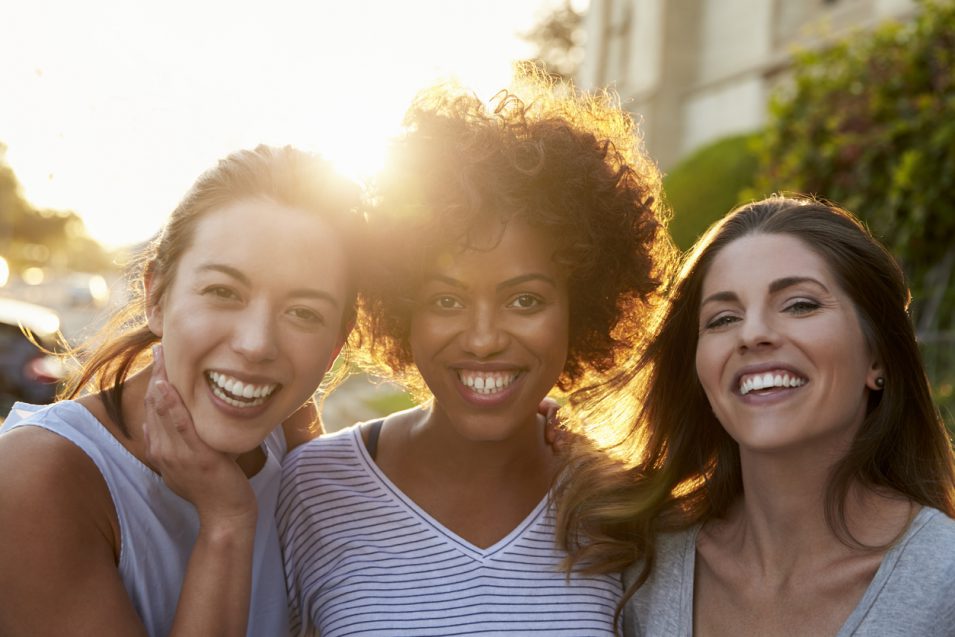 Portrait of three young adult female friends in the street