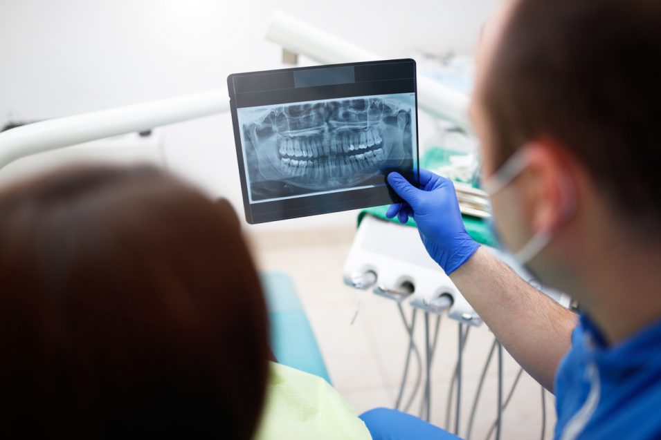 Dentist showing oral radiology results to patient in North York